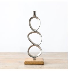 A simplistic candle stand in chrome set on a chunky wooden base.
