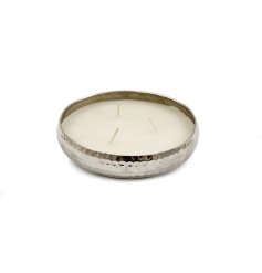 This candle's metallic case features a striking hammered design, making for a bold statement piece.
