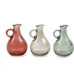 A small glass vase in a jug style design, perfect for placing on a windowsill and watching the sun shine through.