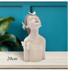 Girl head figurine ideal to placed on a desk, shelf, or mantle, its elegant presence enhances the ambiance of any room.