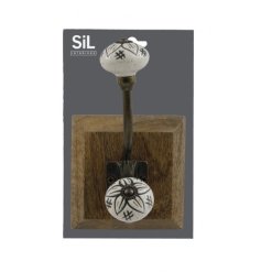 A gorgeous cream and gold wall hook set on a wooden base featuring a stylish flower design. 