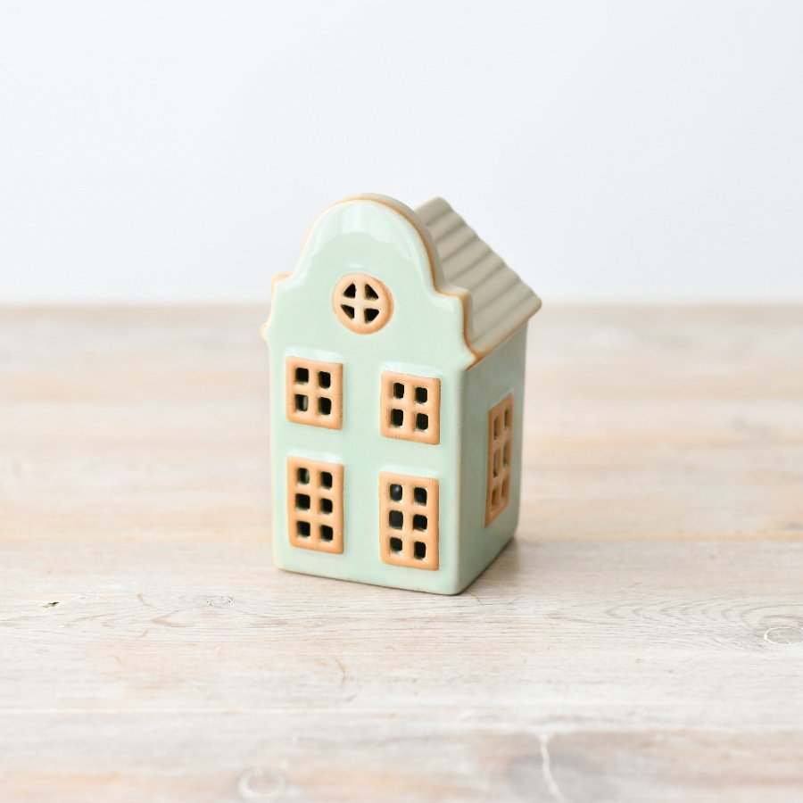 This charming standing house decor adds a touch of whimsy to any space with its cute, pastel green design.