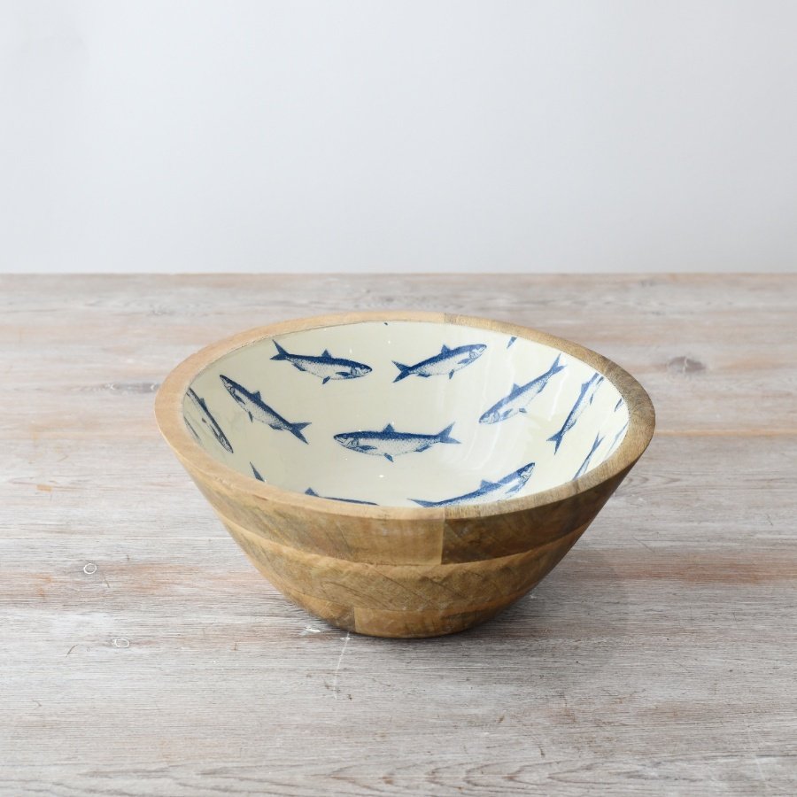 Elevate interiors with a charming wooden bowl adorned in a coastal-inspired enamel pattern.