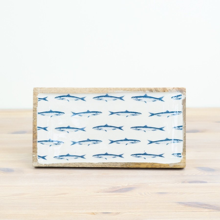 Infuse your home with beachy vibes using this rustic wooden tray featuring a repeated pattern of deep blue fish.