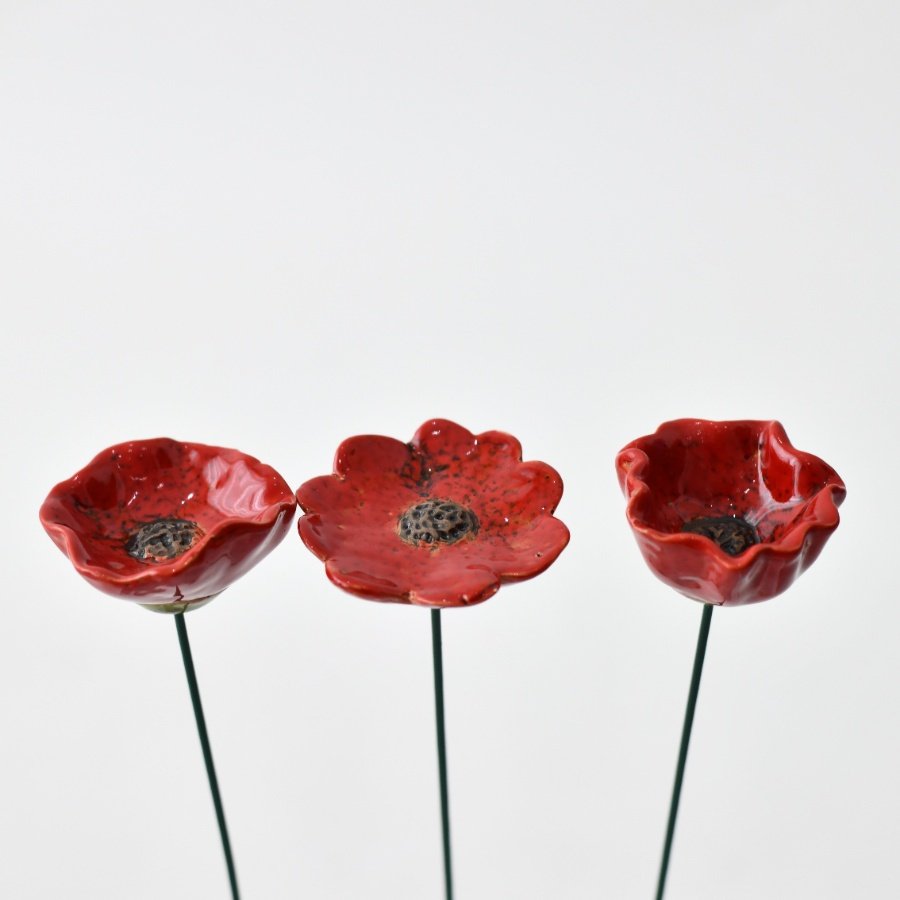 Enhance your flower beds with a burst of color from this poppy garden stake