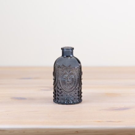 A gorgeous decorative glass bottle in blue featuring the famous Fleur De Lis symbol.