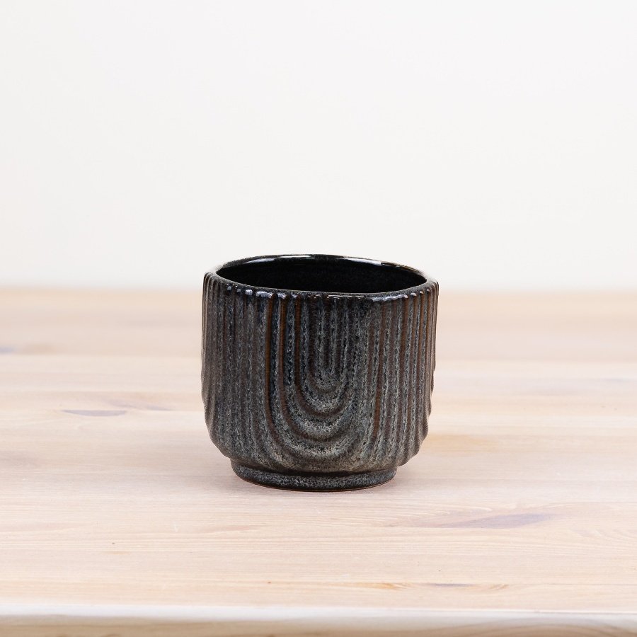 Add a touch of elegance to the living space with this sophisticated ribbed pot.