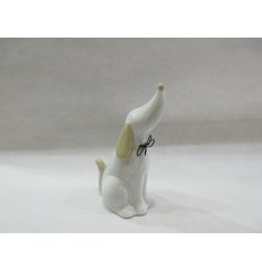 Decorate the home with this charming porcelain dog ornament, complete with a delicate black bow - a must-have for any