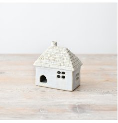 A charming light up house ornament with a thatched style roof design. 