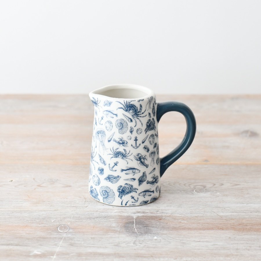 Elevate your kitchenware with a touch of coastal charm from this adorable jug.