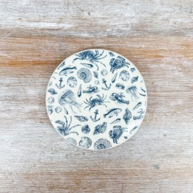 This ceramic coaster showcases a charming sea life design in calming shades of blue.