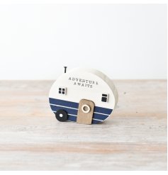 A rustic wooden camper ornament with a coastal coloured design and scripted text.