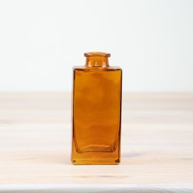 Stylish amber glass vase perfect for adding a pop of color to any room.