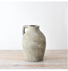 A rustic large jug made from terracotta with a textured surface in a chic neutral colour. 