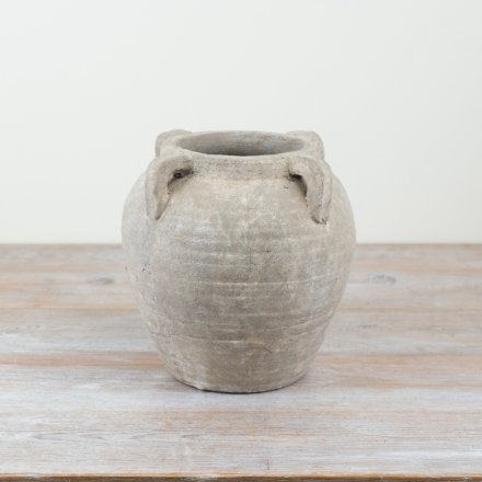A gorgeous stone vase with 4 decorative handles, perfect for creating a statement piece in the home.