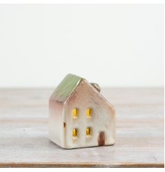 Add cosy light with this 8cm ceramic house featuring a green roof and LED.