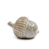 A medium sized glazed acorn ornament in neutral colour tones. 