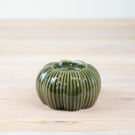 An enchanting t-light holder in the shape of a pumpkin, complete with a natural green glaze.