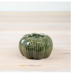 An enchanting t-light holder in the shape of a pumpkin, complete with a natural green glaze.