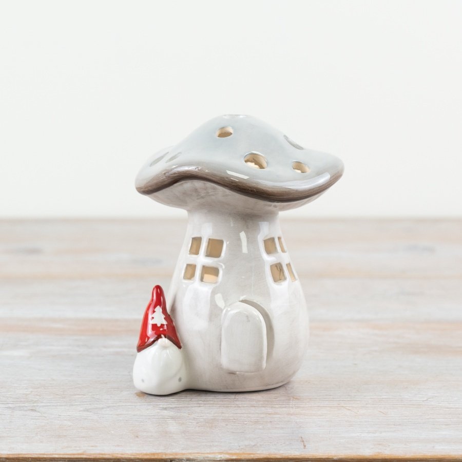 "Adorable grey ceramic candle house with cut-out windows and doors, shaped like a charming mushroom for a whimsical to