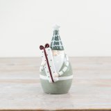 Experience the magic of Christmas with our charming 'Green Santa Holding Present' ornament. 