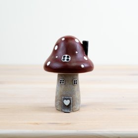 Step into a whimsical world with our charming Red Polyresin Mushroom House Ornament! 
