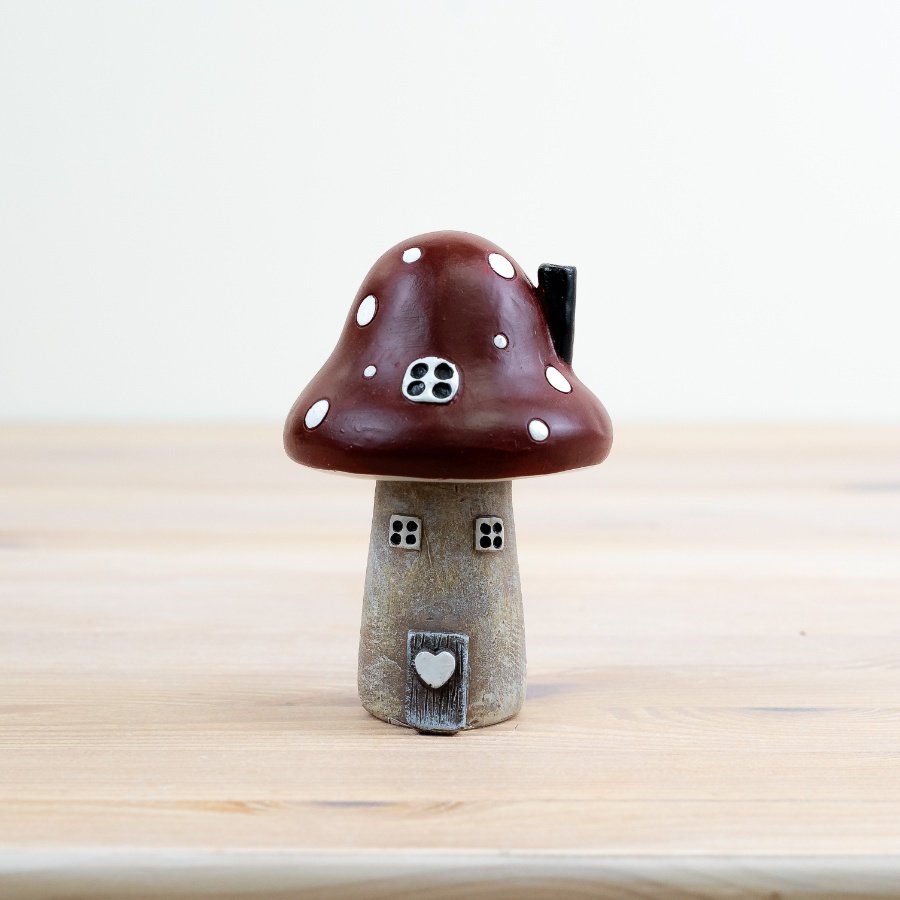Step into a whimsical world with our charming Red Polyresin Mushroom House Ornament! 
