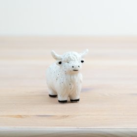 Add a touch of charm to your space with our mini porcelain cow figurine. 