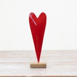 A chic red heart decoration set upon a rustic wooden base. 