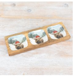 A three compartment tray, each featuring a stunning snowy scene with a highland cow.