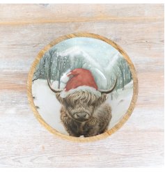 A rustic artisan bowl featuring a colourful Christmas Highland Cow design. 