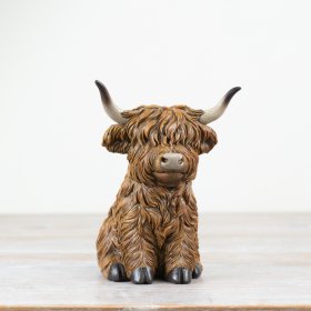 Introducing our charming resin ornament of a sitting highland cow