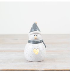 A charming speckled snowman ornament with a heart shaped cut out detail revealing a warm glow led light. 