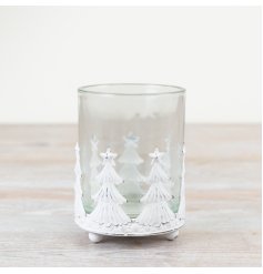 A rustic metal candle holder with star-topped trees and a glass insert