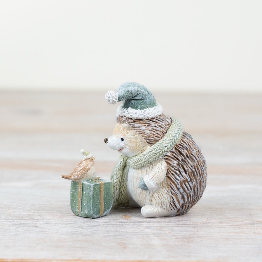 A delightful resin hedgehog adorned with a touch of sparkle, a sage green hat and scar