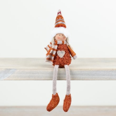An adorable autumnal sitting doll in a burnt orange outfit complete with a scarf and farisle hat. 