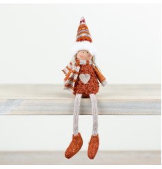An adorable autumnal sitting doll in a burnt orange outfit complete with a scarf and farisle hat. 