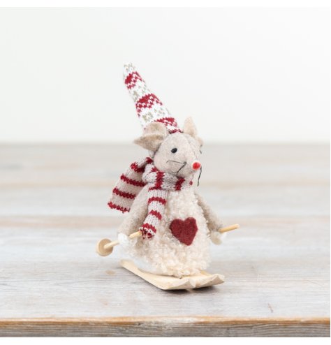 A charming cream mouse skiing in the snow.