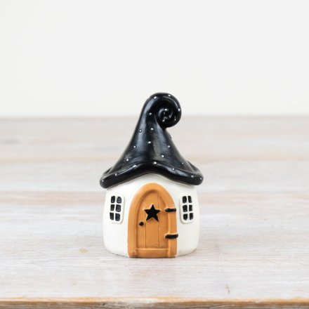 Create a spooky masterpiece with this chic ornamental house in a quirky shape with a wooden style door and black roof.