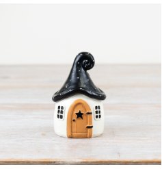 Create a spooky masterpiece with this chic ornamental house in a quirky shape with a wooden style door and black roof.