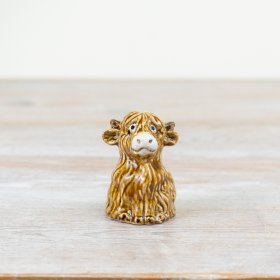 A hand finished highland cow ornament. A rustic accessory with a rich glaze and fantastic detailing.