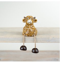 A charming highland cow shelf sitter with dangling legs. Quirky, original and hand finished.