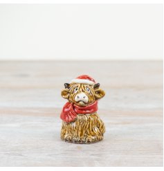 A quirky and unique Christmas highland cow with Santa hat and scarf. Hand finished and painted with a rich glaze. 