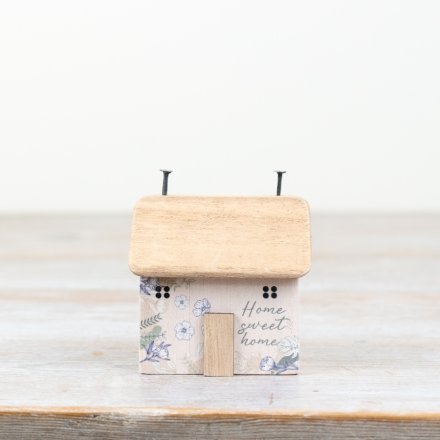 "Unique, charming pink block house ornament with intricate flower design. 