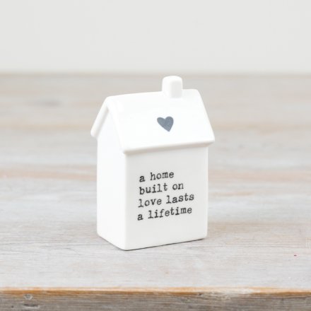 A charming house-shaped ornament in white, perfect for adding a touch of meaning to any space.