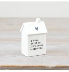 A charming house-shaped ornament in white, perfect for adding a touch of meaning to any space.