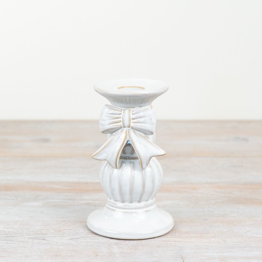 A stunning ceramic candle holder adorned with a beautiful bow. 