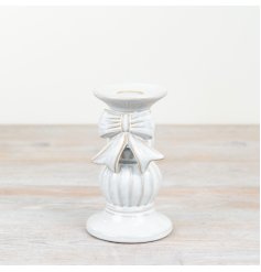 Elevate the ambiance of any living space with this beautiful ceramic candle holder adorned with a charming bo