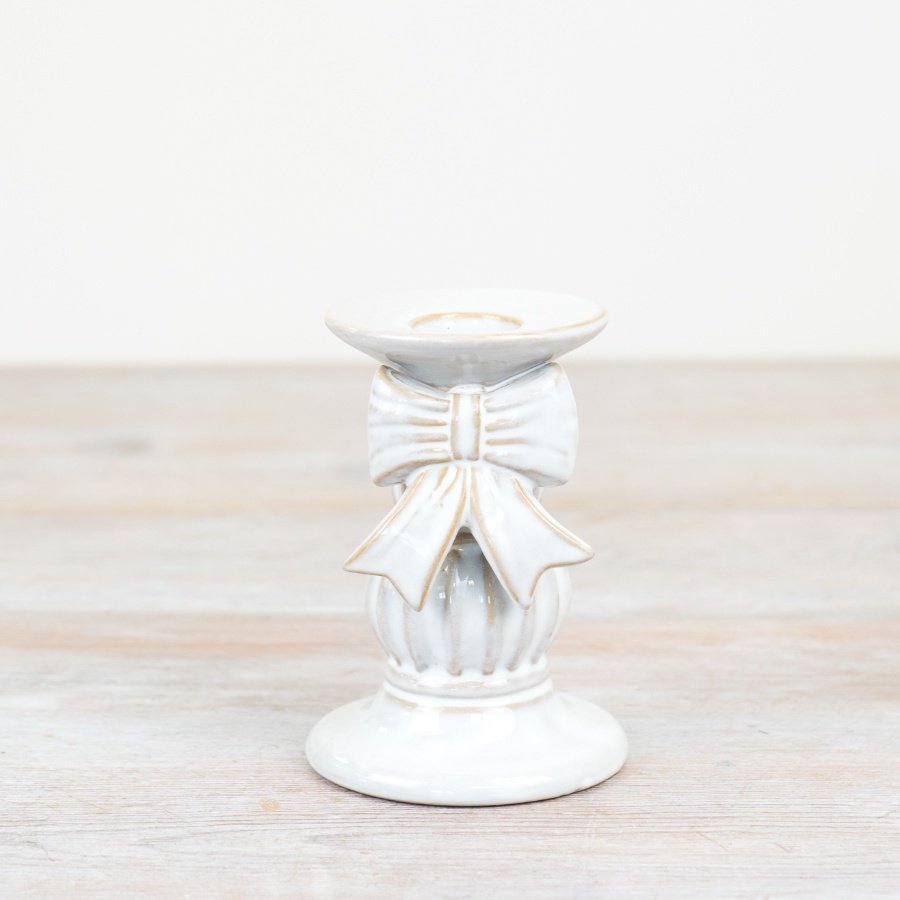 Exquisite candle holder with elegant white bow design. Adds a charming touch to any room. 