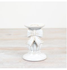 Add elegance to your home with a gorgeous candle holder featuring a beautiful white bow design.